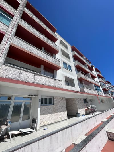 Fachada de prédio antes da obra, com reboco manchado, pintura desbotada e palas das varandas degradadas